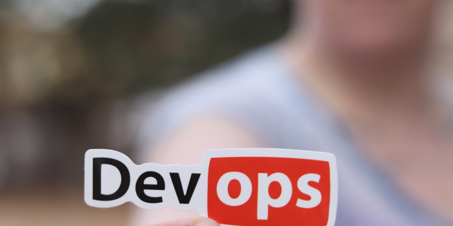 a blurred out picture ofa man holding a cut out devops sign
