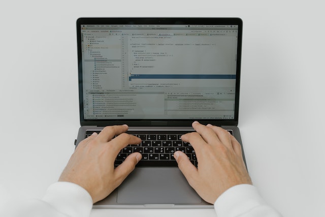 a man coding on his laptop with low code development